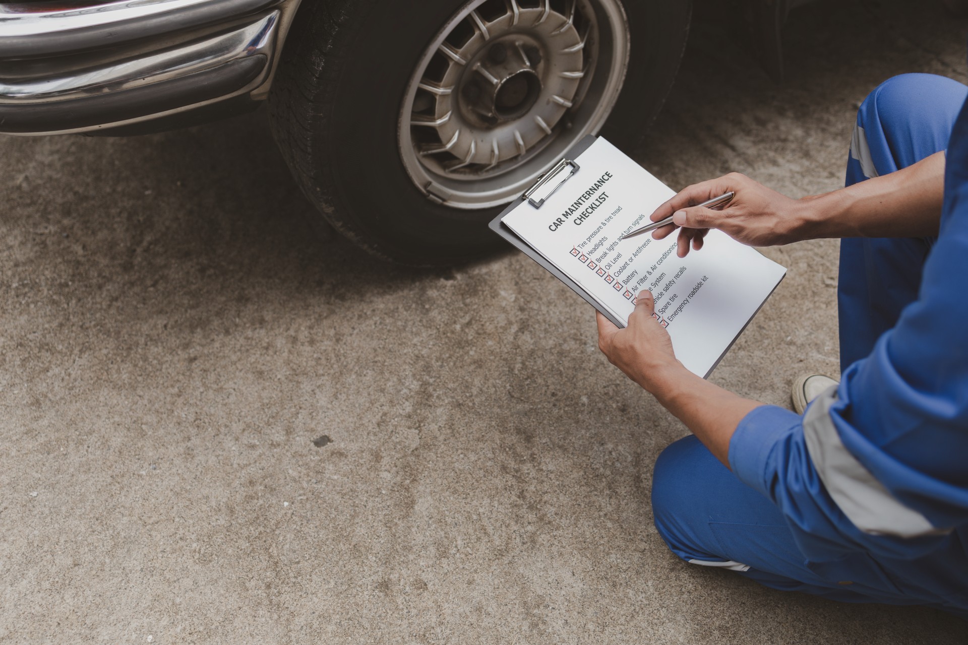 Car mechanic is inspecting tires and replacing worn tires through long hours of work, car repairs, car breakdowns, punctured tires. Concept of car tire maintenance and car repair.